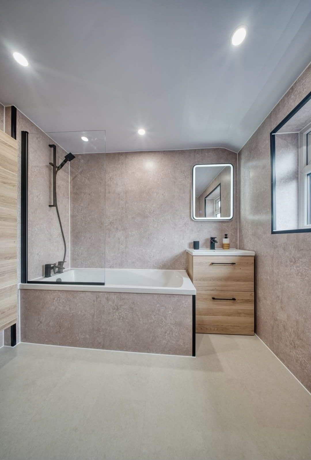 Panelled bath with shower screen, oak vanity drawers and illuminated mirror