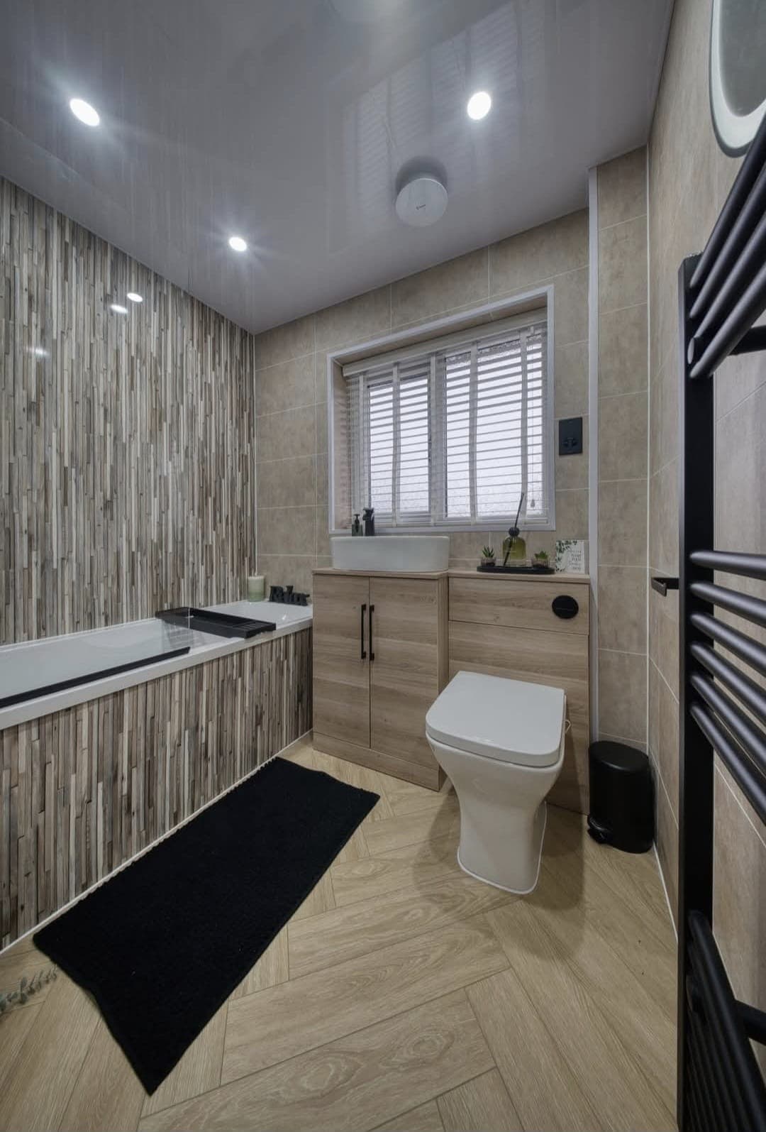 Bathroom with grooved timber-effect wall panels, built-in bath and oak vanity unit