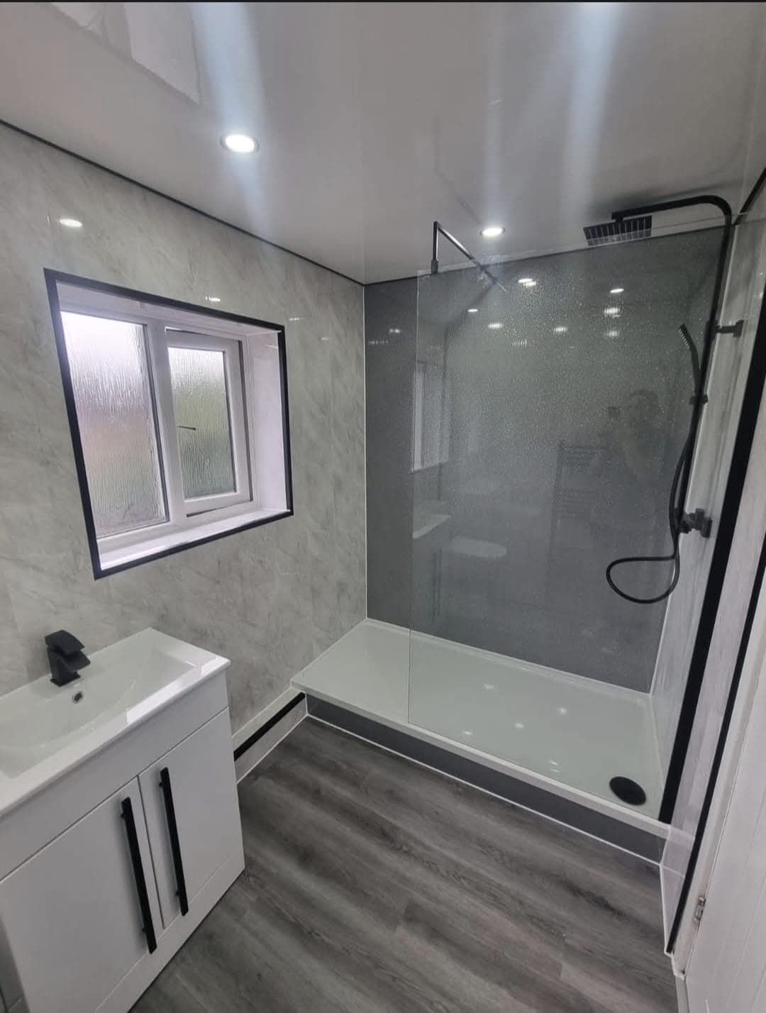 Bathroom with walk-in shower tray, glass screen and white vanity unit