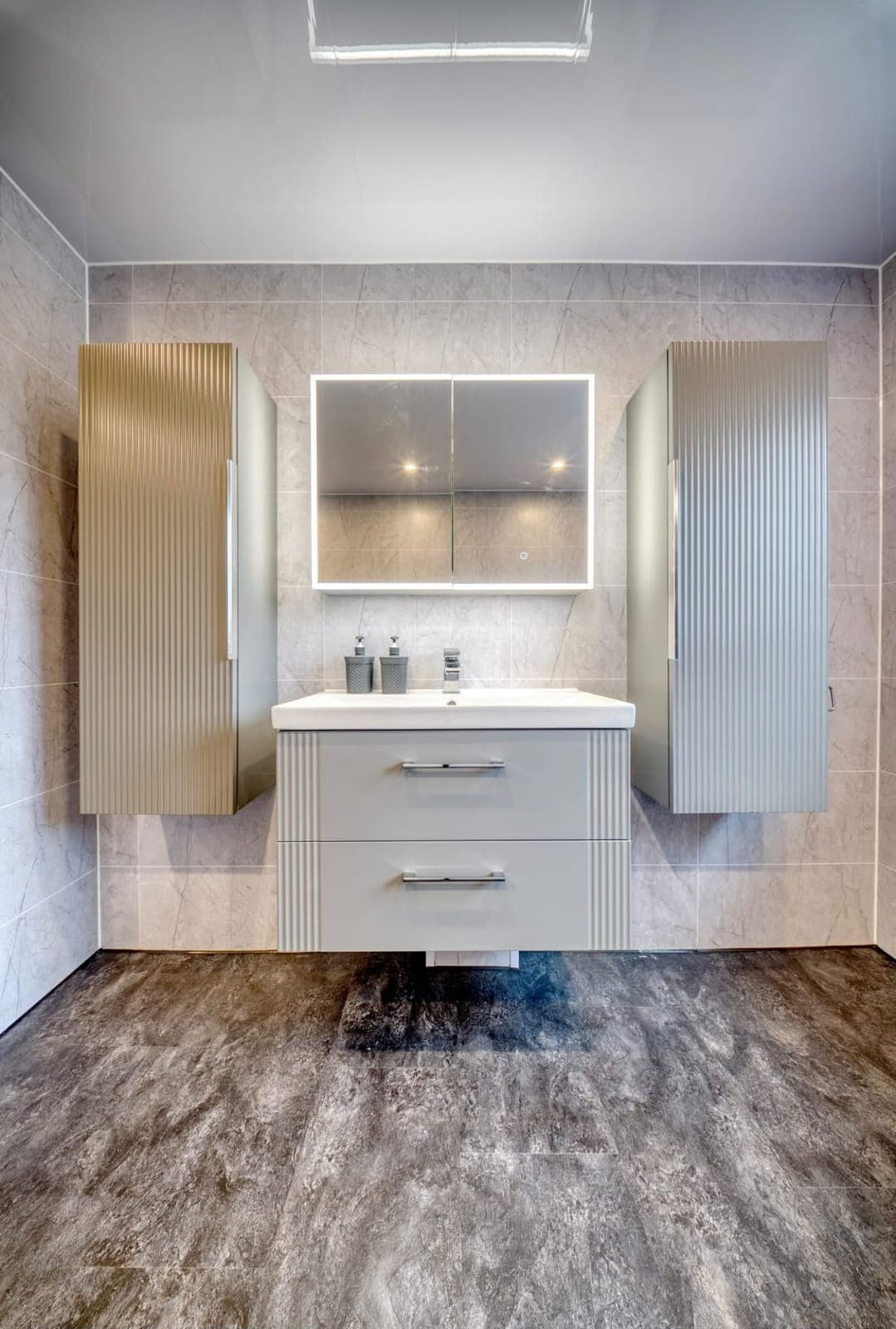 Bathroom with wall-hung vanity, LED mirror cabinet and tall storage units