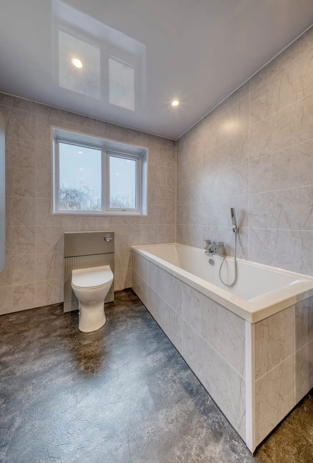 Bathroom with built-in bath, concealed cistern toilet and window