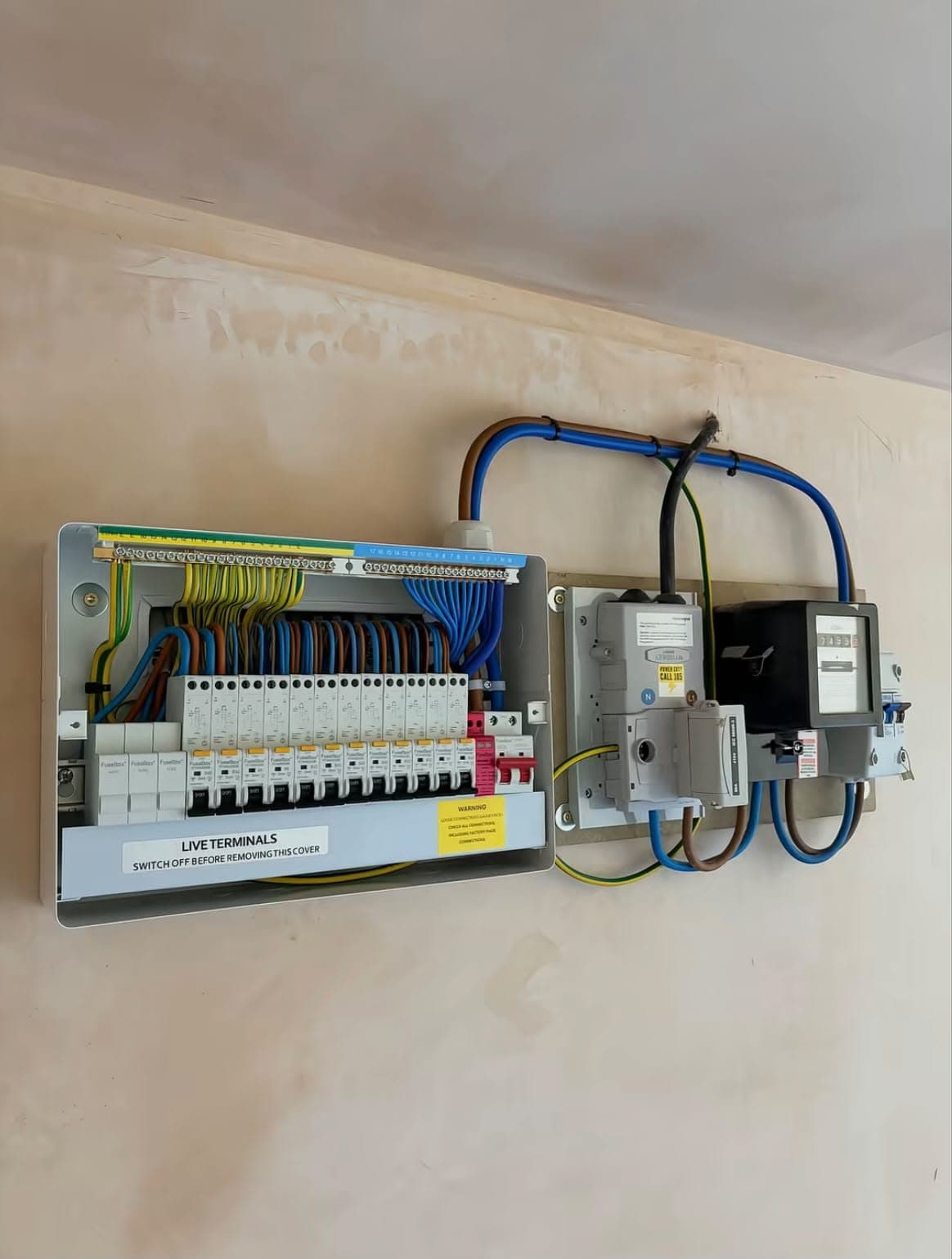 New consumer unit with labelled circuits and tidy cable runs on a plastered wall