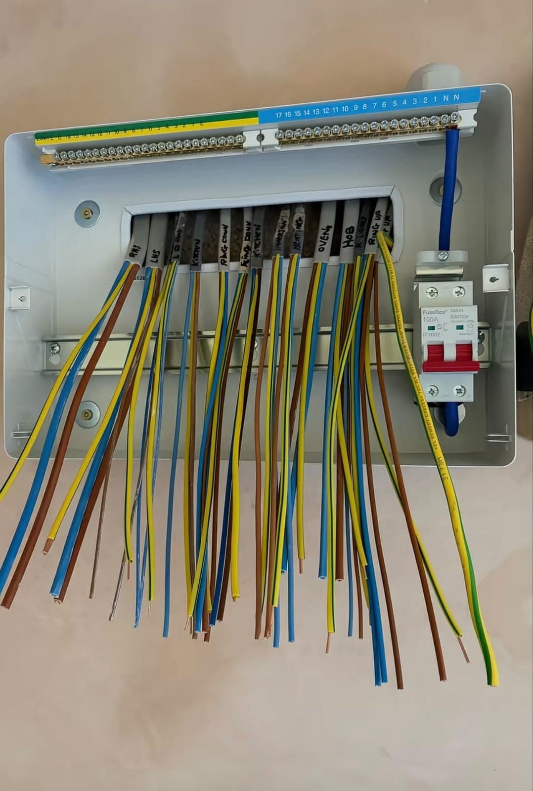 Consumer unit being wired, with coloured cables ready for connection