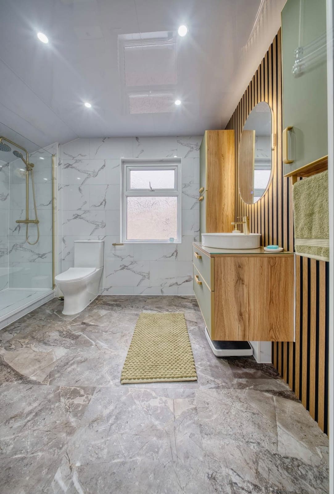 Marble-effect bathroom with oak vanity, walk-in shower and yellow bath mat